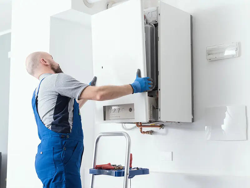 Installation d'une chaudière murale à gaz par un technicien